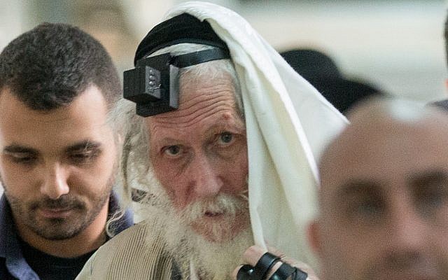 Rabbi Eliezer Berland shrouds himself with his talit (prayer shawl) at the Magistrates Court in Jerusalem, as he is put on trial for sexual assault charges, November 17, 2016. (Yonatan Sindel/ Flash90)