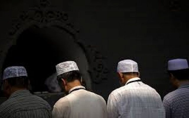 In this July 18, 2015, file photo, Chinese Hui Muslims pray during Eid al-Fitr prayers at Niujie Mosque in Beijing. (AP Photo/Mark Schiefelbein, File)