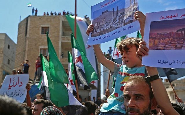 Syrian protesters wave their national flag as they demonstrate against the regime and its ally Russia, in the rebel-held city of Idlib on September 7, 2018. (AFP/Zein Al Rifai)