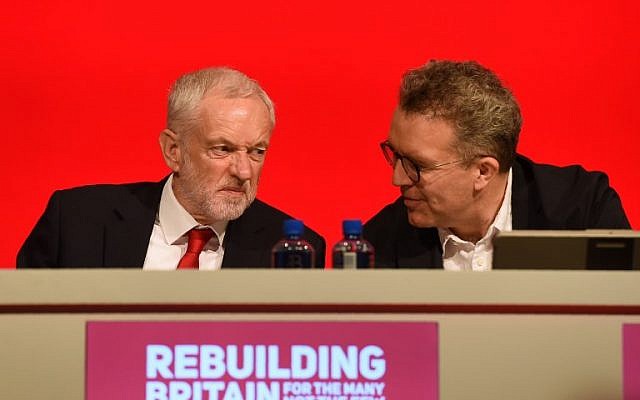 Britain's opposition Labour Party leader Jeremy Corbyn (L) chats with Tom Watson deputy leader of Britain's opposition Labour Party on stage at the Labour Party Conference in Liverpool, England on September 23, 2018, the official opening day of the annual Labour Party Conference. (AFP PHOTO / Paul ELLIS)