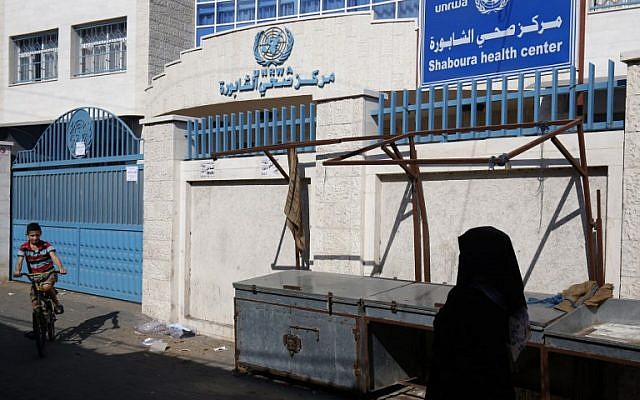 A Palestinian woman walks past a closed health center that run by United Nations Relief and Works Agency (UNRWA) during a strike of all UNRWA institutions in Rafah in the southern Gaza Strip on September 24, 2018. (AFP PHOTO / SAID KHATIB)