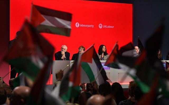 Delegates at the Labour Party's conference in Liverpool hold up Palestinian flags during a debate on September 25, 2018, as leader Jeremy Corbyn looks on from the podium. (AFP Photo/Oli Scarff)