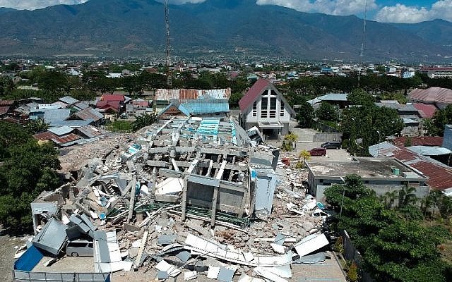 This aerial picture shows the remains of a ten-storey hotel in Palu in Indonesia’s Central Sulawesi on September 30, 2018, after it collapsed following a strong earthquake in the area. (AFP PHOTO / Azwar)