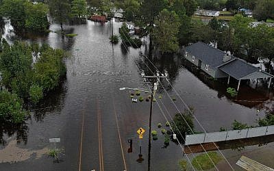 Flood waters from Hurricane Florence surround a house and flow along the street in Fayetteville, North Carolina, on September 16, 2018. (Joe Raedle/Getty Images/AFP)