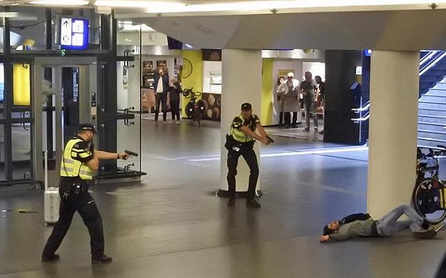 Dutch police officers point their guns at a wounded 19-year-old man, who was shot by police after stabbing two people in the central railway station, in Amsterdam, the Netherlands, August 31, 2018. (AP Photo)