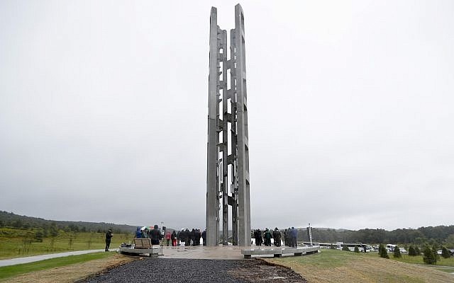 In this Sept. 9, 2018 file photo, people attending the dedication stand around the 93-foot tall Tower of Voices at the Flight 93 National Memorial in Shanksville, Pa., where the tower contains 40 wind chimes representing the 40 people that perished in the crash of Flight 93 in the terrorist attacks of Sept. 11, 2001. (AP Photo/Keith Srakocic, Pool)