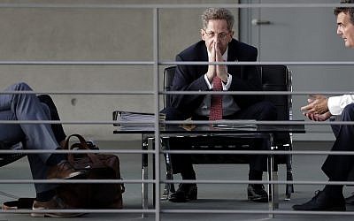 In this Wednesday, Sept. 12, 2018 photo Hans-Georg Maassen, center, head of the German Federal Office for the Protection of the Constitution, waits for the beginning of a hearing at the home affairs committee of the German federal parliament, Bundestag, in Berlin, Germany.  (AP Photo/Michael Sohn)