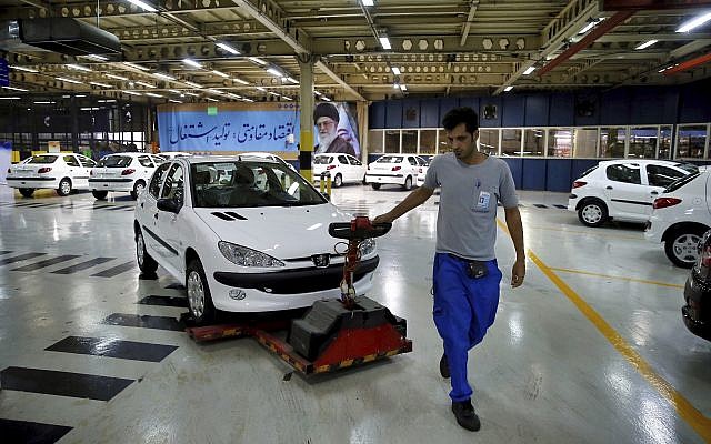 In this Sunday, September 9, 2018 photo, a worker moves a new car at the Iran Khodro automobile manufacturing plant, just outside Tehran, Iran. (AP Photo/Ebrahim Noroozi)