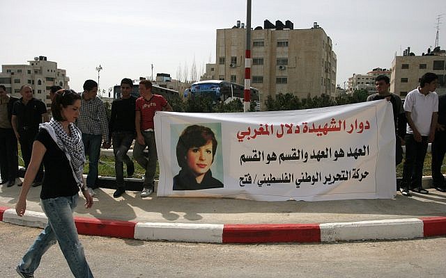 In this photo from March 11, 2010, Palestinians hold a banner displaying a picture of Palestinian Dalal Mughrabi, a Palestinian terrorist who killed dozens of Israeli civilians in a 1978 bus hijacking in Israel, seen in portrait, as they protest in the West Bank city of Ramallah. (AP Photo/Majdi Mohammed)