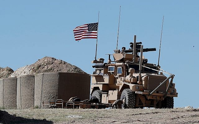A US soldier sits on an armored vehicle at a newly installed position in Manbij, north Syria, April 4, 2018. (Hussein Malla/AP)