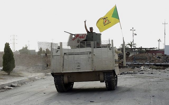 In this Wednesday, May 27, 2015 photo, a fighter on an armored vehicle belonging to the Iran-backed Shiite Hezbollah Brigade waves a v-sign as he patrols east of Ramadi, Iraq. (AP)