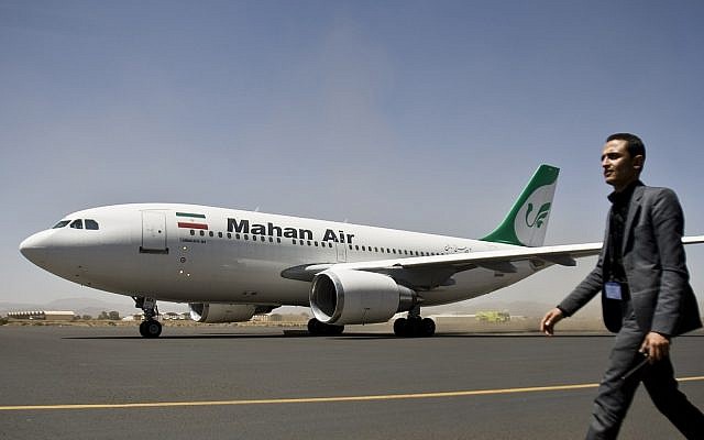 A Yemeni airport security official walks on the tarmac next to a plane from the Iranian private airline Mahan Air at the international airport in Sanaa, Yemen, March 1, 2015 (AP Photo/Hani Mohammed)