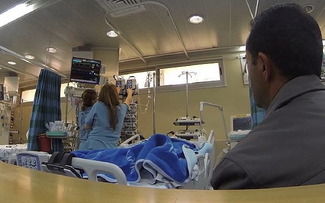 Illustrative: A father waits while hospital staff attend to his baby, brought to Israel for life-saving heart surgery by Shevet Achim NGO. (Screen capture: Vimeo)
