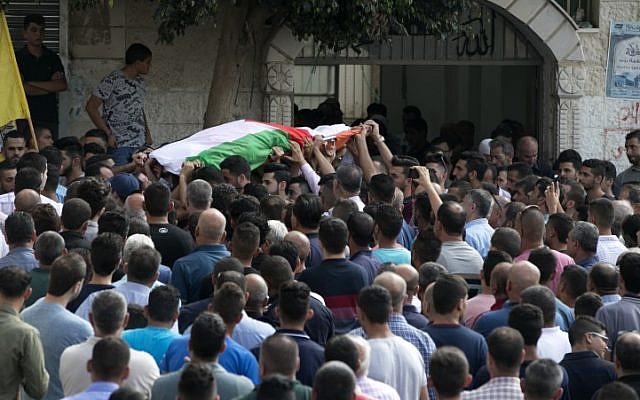 Palestinian carry the body of 48-year-old mother of eight, Aisha Rabi, who died of her wounds after the car she was travelling in with her husband was hit by stones, during her funeral in the West Bank village of Biddya, on October 13, 2018. (JAAFAR ASHTIYEH / AFP)