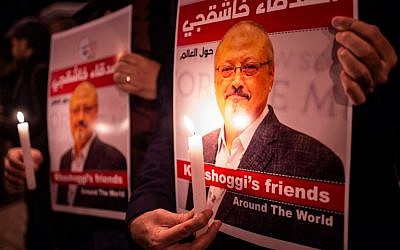 People hold posters picturing Saudi journalist Jamal Khashoggi and candles during a gathering outside the Saudi Arabia consulate in Istanbul, on October 25, 2018. (Yasin Akgul/AFP)