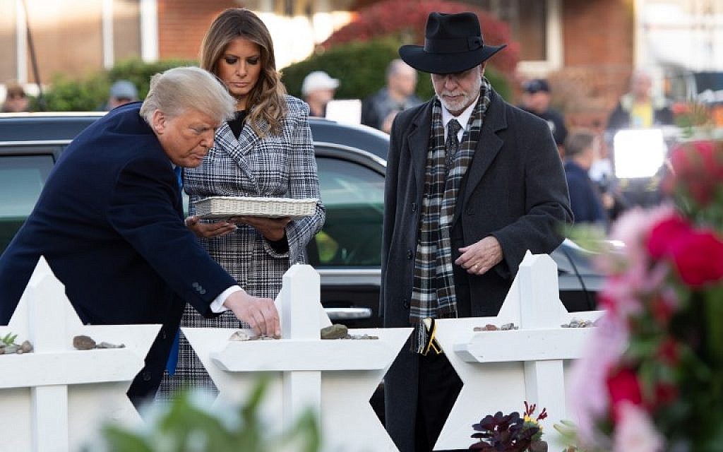 US President Donald Trump and First Lady Melania Trump, accompanied by Rabbi Jeffrey Myers, place stones and flowers on a memorial as they pay their respects at the Tree of Life synagogue in Pittsburgh, Pennsylvania, on October 30, 2018. (Saul Loeb/AFP)