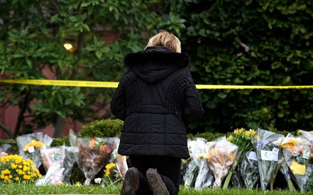 A mourner prays after laying flowers at the site of the mass shooting that killed 11 people and wounded 6 at the Tree Of Life Synagogue on October 28, 2018 in Pittsburgh, Pennsylvania.  (Jeff Swensen/Getty Images/AFP)
