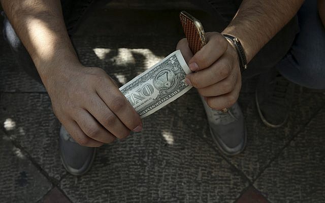 An Iranian street money exchanger holds a US banknote in downtown Tehran, Iran, October 2, 2018. (AP Photo/Vahid Salemi)