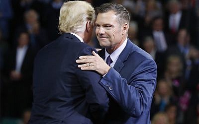 US President Donald Trump, left, on stage with Republican gubernatorial candidate Secretary of State Kris Kobach, right, during a campaign rally at Kansas Expocentre, October 6, 2018 in Topeka, Kansas. (AP Photo/Pablo Martinez Monsivais)