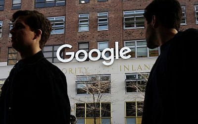 People walk by Google's offices in New York, December 4, 2017. (AP Photo/Mark Lennihan, File)