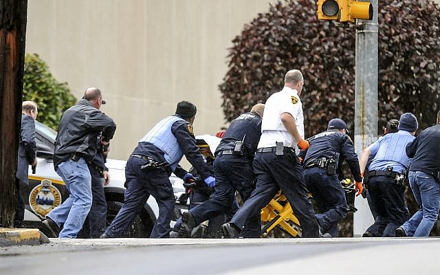 Las fuerzas del orden público corrieron con una persona en una camilla en la escena donde varias personas recibieron disparos, el sábado 27 de octubre de 2018, en la Congregación del Árbol de la Vida en el vecindario Squirrel Hill de Pittsburgh.  (Alexandra Wimley / Pittsburgh Post-Gazette a través de AP)