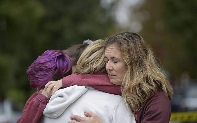From left: Cody Murphy, 17, Sabrina Weihrauch, and Amanda Godley, all of Pittsburgh, hug after an active shooter situation at Tree of Life Synagogue on Saturday, Oct. 27, 2018. (Andrew Stein/Pittsburgh Post-Gazette via AP)