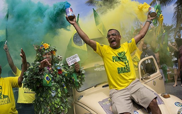 Supporters of presidential front-runner Jair Bolsonaro sing the national anthem outside his residence in Rio de Janeiro, Brazil, Sunday, Oct. 28, 2018, during the country's presidential runoff election.(AP Photo/Silvia Izquierdo)