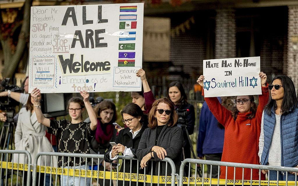 Members of the crowd hold up signs as President Donald Trump and first lady Melania Trump visit the Tree of Life Synagogue in Pittsburgh, Tuesday, Oct. 30, 2018. (AP Photo/Andrew Harnik)
