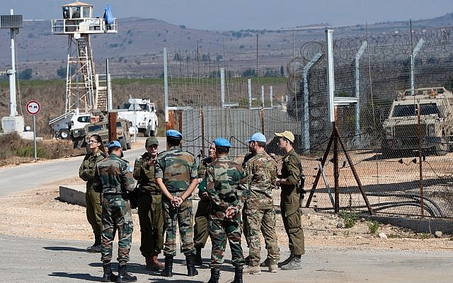 UN peacekeepers and Israeli soldiers are seen on the Israeli side of the Quneitra Crossing between Israel and Syria in the Golan Heights on September 27, 2018. (Basel Awidat/Flash90)