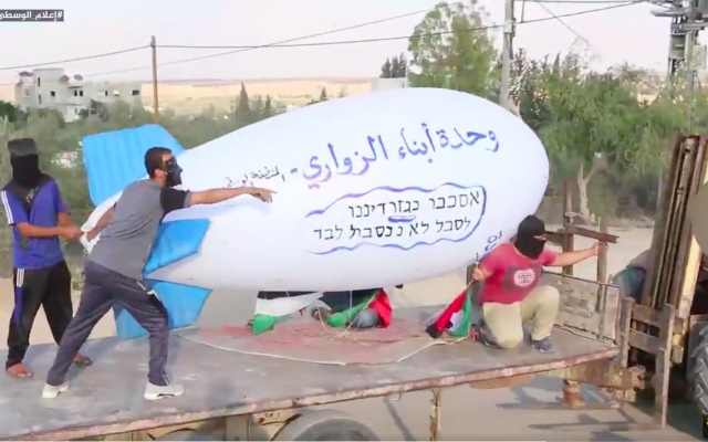 Palestinians transport an incendiary blimp to launch over the Gaza border into Israel on October 13, 2018. (screen capture: Twitter)