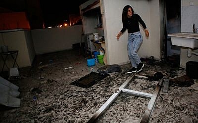 An Israeli woman inspects the damage in an apartment that was hit by a rocket fired from the Gaza Strip, in the southern Israeli town of Ashkelon on November 12, 2018. (GIL COHEN-MAGEN / AFP)