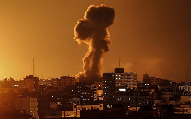 A picture taken on November 12, 2018, shows smoke rising above the building housing the Hamas-run television station al-Aqsa TV in the Gaza Strip during an Israeli air strike.  (Mahmud Hams / AFP)