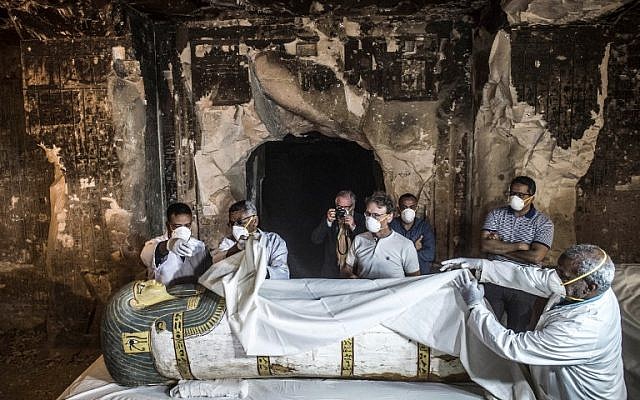 Egypt's Antiquities Minister Khaled el-Enany (R) and Mostafa Waziri (2nd-R, behind), the Secretary General of the Supreme Council of Antiquities, inspect an intact sarcophagus during its opening at the site of Tomb TT33 at Al-Assasif necropolis on the west bank of the Nile north of the southern Egyptian city of Luxor on November 24, 2018, after it was discovered earlier this month by a French mission. (Khaled DESOUKI / AFP)