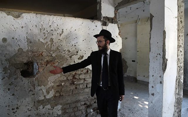 Rabbi Israel Kozlovsky, the director of Nariman Chabad House, gestures at shrapnel marks left from the 2008 terror attacks, during a media visit on the eve of the tenth anniversary of the attacks in Mumbai on November 25, 2018 (PUNIT PARANJPE / AFP)