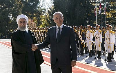 Iraqi President Barham Salih, right, and his Iranian counterpart Hassan Rouhani shake hands during an official welcome ceremony for Salih at the Saadabad Palace in Tehran, Iran, Saturday, November 17, 2018.  (Iranian Presidency Office via AP)