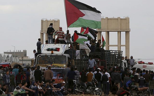Illustrative: Protesters wave Palestinian flags while riding a truck full with tires near the fence of the Gaza Strip border with Israel during a protest east of Gaza City, Friday, October 26, 2018. (AP/Adel Hana)