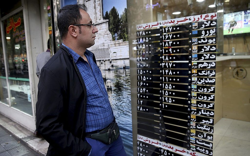 An Iranian checks various currency rates at an exchange shop window in downtown Tehran, Iran, November 5, 2018. (AP/Ebrahim Noroozi)