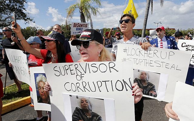 A crowd protests outside the Broward County Supervisor of Elections office Friday, Nov. 9, 2018, in Lauderhill, Fla. A possible recount looms in a tight Florida governor, Senate and agriculture commission race. (AP Photo/Joe Skipper)