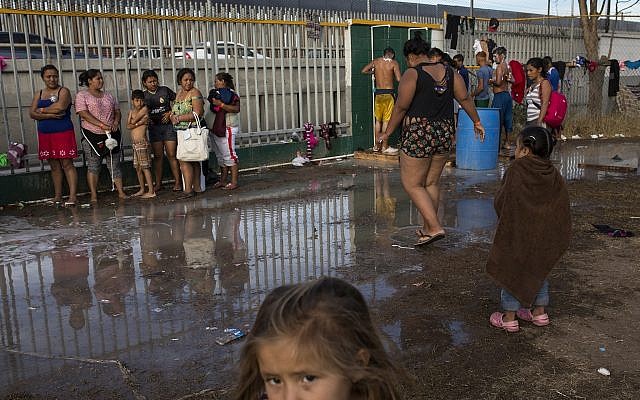Central American migrants have a bath at a temporary shelter, near barriers that separate Mexico and the United States, in Tijuana, Mexico, Wednesday, Nov. 21, 2018. Migrants camped in Tijuana after traveling in a caravan to reach the U.S are weighing their options after a U.S. court blocked President Donald Trump’s asylum ban for illegal border crossers. (AP Photo/Rodrigo Abd)