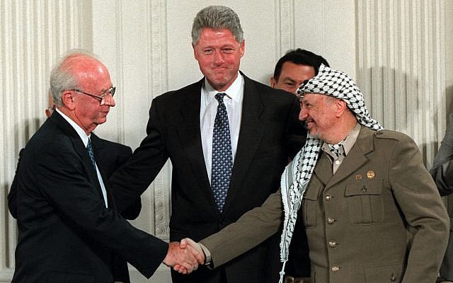 President Clinton gestures toward Israeli Prime Minister Yitzhak Rabin, left, and PLO leader Yasser Arafat shaking hands in the East Room of the White House Thursday Sept. 28, 1995. Egyptian President Hosni Mubarak looks on behind Arafat. (AP Photo/Doug Mills)