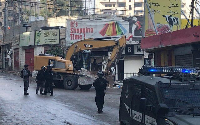 Police accompany bulldozers demolishing storefronts in the Shuafat Refugee Camp in East Jerusalem, November 21, 2018. (Courtesy Ir Amim)