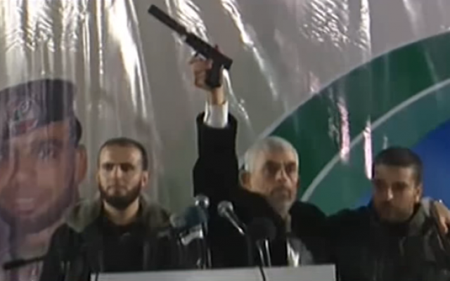 In this November 16, 2018 image, Hamas's Gaza chief Yahya Sinwar holds up a handgun with a silencer he says was captured from Israeli special forces during a firefight in the Gaza Strip on November 11 (YouTube screenshot)