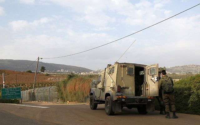 This picture taken on December 4, 2018 near the northern Israeli town of Metula, shows Israeli soldiers standing outside a military vehicle near the border with Lebanon. (JALAA MAREY / AFP)