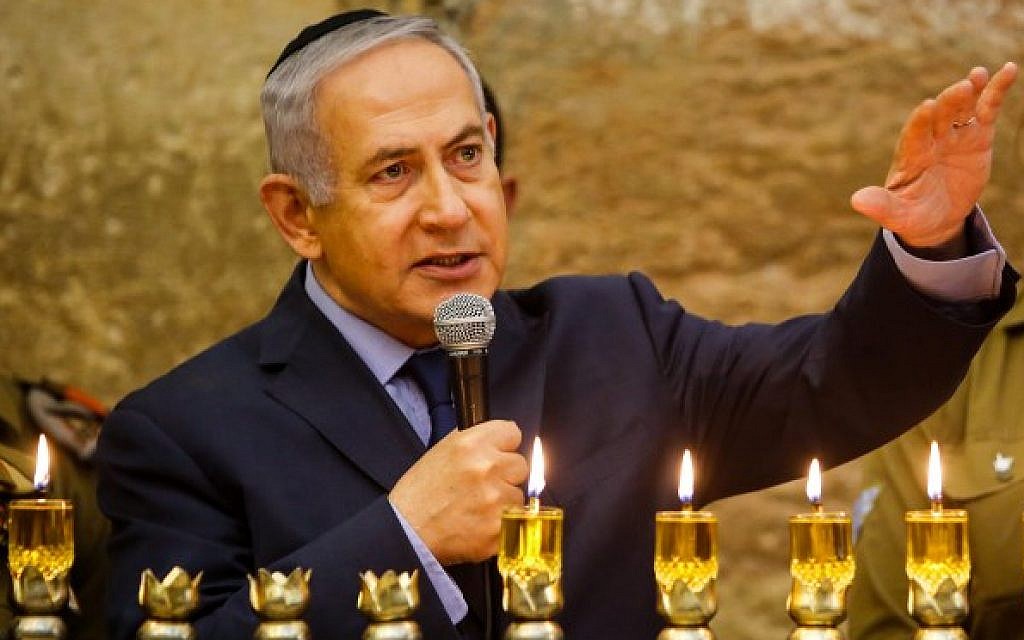 Prime Minister Benjamin Netanyahu (L) speaks during a candle lighting ceremony marking the Hanukkah festival at the Western Wall in the Old City of Jerusalem on December 6, 2018. (Gil Cohen-Magen/Pool/AFP)