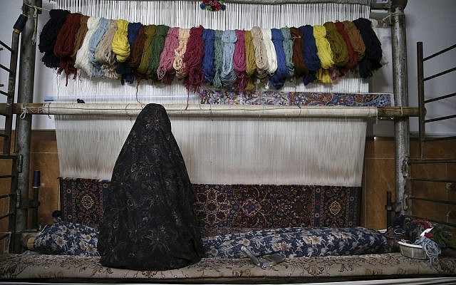 In this photo from December 10, 2018, a woman weaves a Persian carpets at her home in Kashan, Iran. (AP Photo/Vahid Salemi)