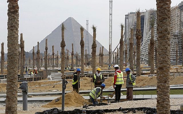 In this December 16, 2018 photo, workers landscape grounds at the Grand Egyptian Museum under construction in front of the Pyramids in Giza, Egypt. (AP Photo/Amr Nabil)