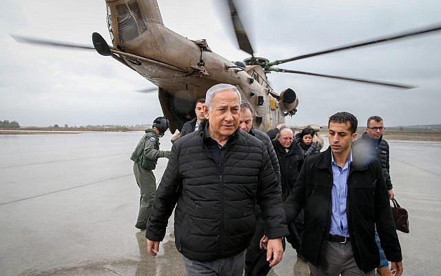 Prime Minister Benjamin Netanyahu walks out of a helicopter as he arrives in northern Israel, December 6, 2018 (Amit Shabi/Yedioth Ahronoth/POOL)