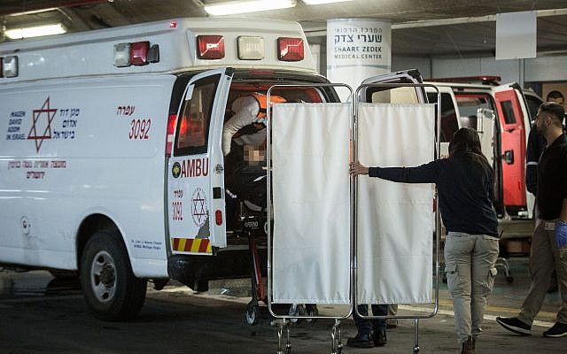 Israeli security and medical personnel evacuate an Israeli woman from an ambulance at the Shaarei Tzedek Medical Center in Jerusalem, after she was was seriously injured in a terror attack in Ofra, December 9, 2018. (Hadas Parush/Flash90)