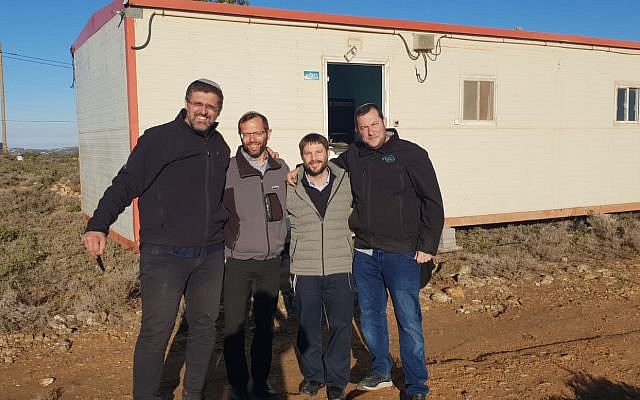 FILE: (From L-R) Amona leader Avichay Buaron, Binyamin Regional Council chairman Yisrael Gantz, Jewish Home MK Bezalel Smotrich and Samaria Regional Council chairman Yossi Dagan stand in front of a new caravan that was installed on the hilltop where the illegal Amona outpost once stood on December 14, 2018. (Campaign to save Amona)