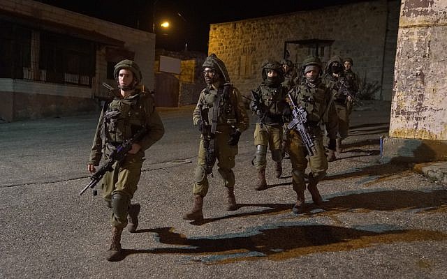 Israeli soldiers search for gunmen who opened fire at a bus stop outside the West Bank settlement of Ofra, injuring seven people, on December 9, 2018. (Israel Defense Forces)